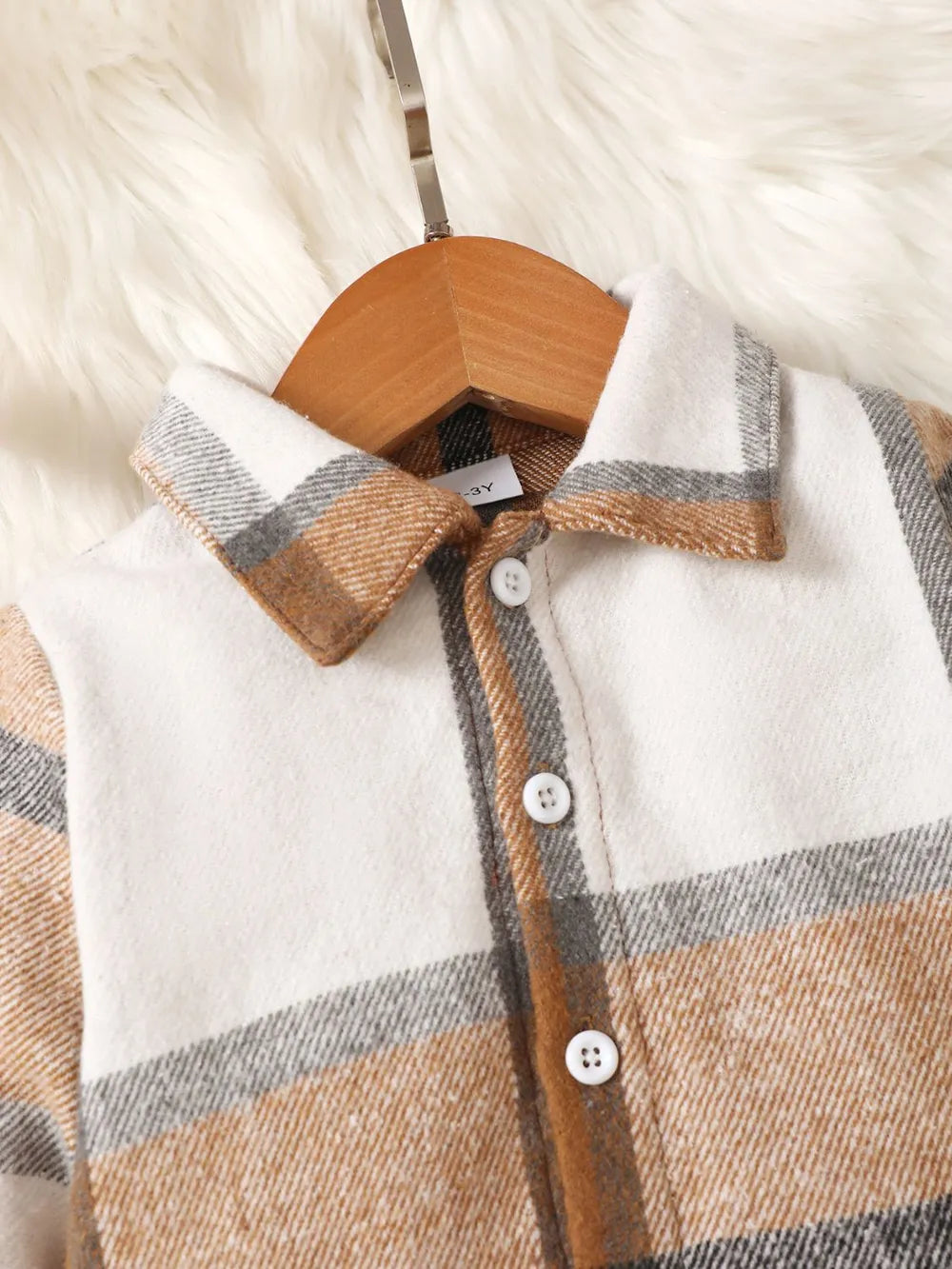 children's two-piece outfit with a button up color block top and matching pants displayed on flat neutral lighting